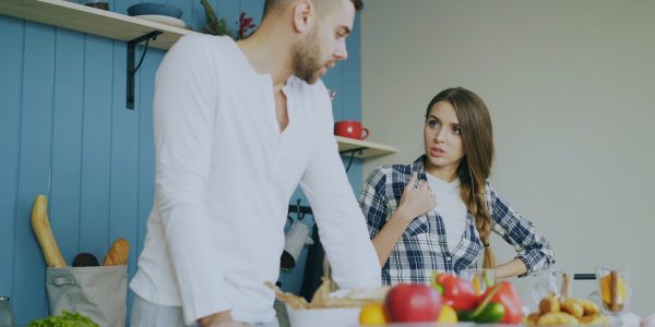 Young couple quarrels in the kitchen during breakfast time in the morning at home